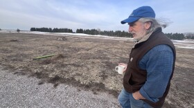 Jim Lively has a local food market just minutes from the Sleeping Bear Dunes National Lakeshore in northern Michigan. He’s waiting for the federal money he was promised so he can put solar on the roof and offset the costs of opening up a campsite for RVs in this field. (Photo: Izzy Ross/IPR News)