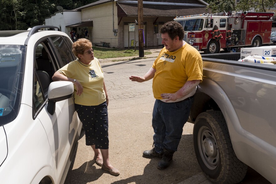 Hundred VFD President Johanna Lemasters and volunteer Jason Miller talk outside the VFD’s new, but recently flooded, building in Hundred, W.Va.