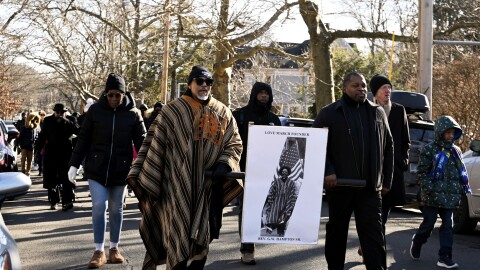 Rev. Kennedy Hampton leads the 55th annual Rev. Dr. Martin Luther King Love March in New Haven on January 15th, 2025. He holds a sign representing his father, George Hampton who founded the march in 1971.