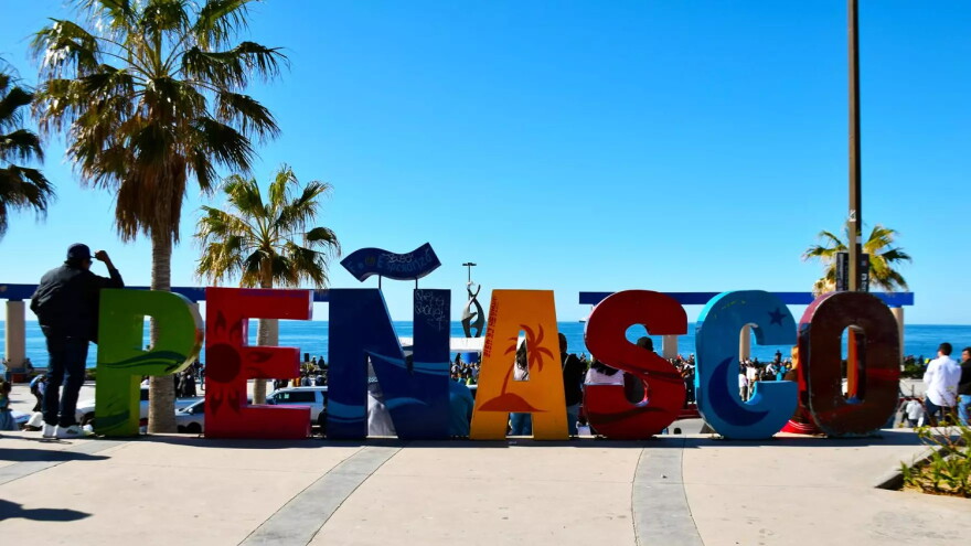 multi color letter spell out Penasco on beach front