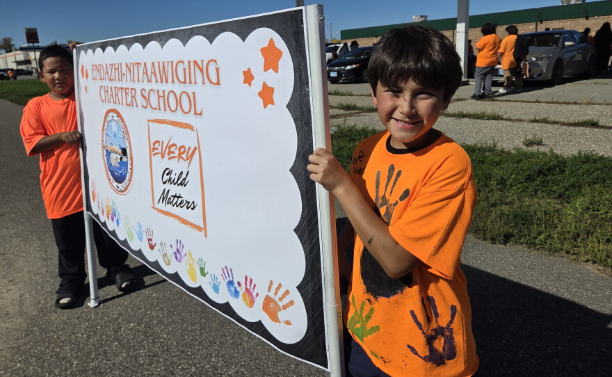 Endazhi Nitaawiging students Blaze and Damon hold a sign for the school's Orange Shirt Day walk on Sept. 30, 2026, in Red Lake.