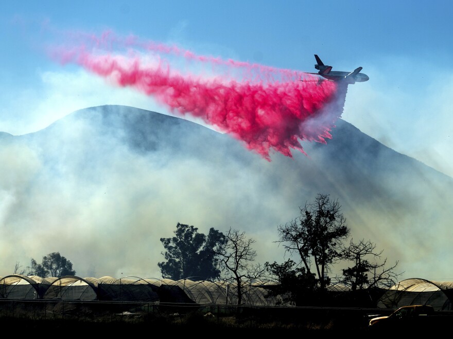 An air tanker drops retardant as the Maria Fire approaches Santa Paula, Calif., on Friday. [Noah Berger / AP]