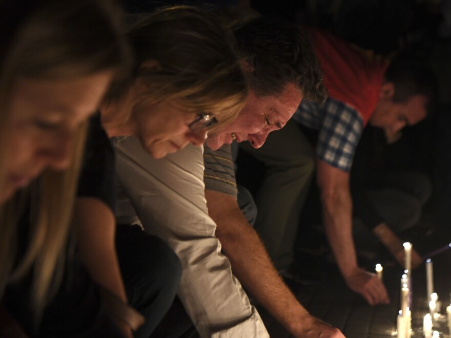 People place candles in front of the Politecnico high school in Rosario, Argentina, which five of those killed in a truck attack Tuesday had attended as teenagers.