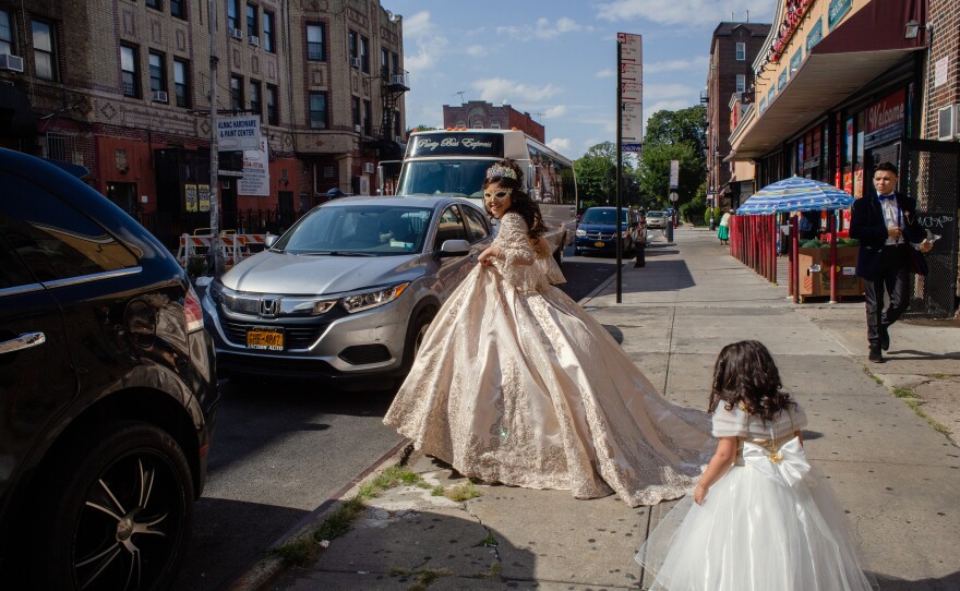 Citlaly Olvera Salazar holds up her gown as she walks towards her party bus.