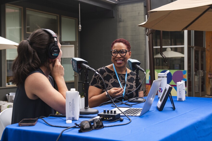 Jenn White (right) tells Aspen Public Radio’s All Things Considered Host Halle Zander how her national show, 1A, incorporates listener voices to help inform discussions outside the Red Brick Center for the Arts on June 26, 2024. The conversation was part of an hourlong broadcast during Aspen Public Radio’s annual Lawn Bash celebration.