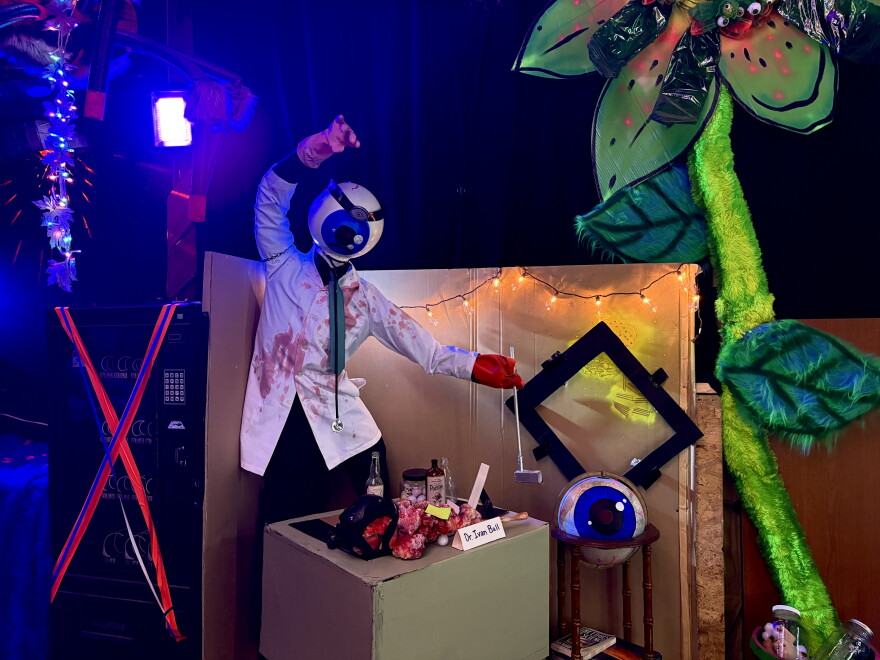 A figure of an eyeball with a lab coat and a lobster claw at a desk.