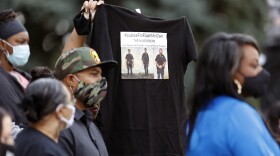 A supporter holds up a shirt to call attention to the death of Elijah McClain in August 2019 in Aurora, Colorado., during a news conference after Colorado Gov. Jared Polis signed a broad police accountability bill on June 19, 2020. (David Zalubowski/AP)