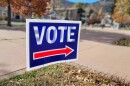 A red, white and blue lawn sign reads 