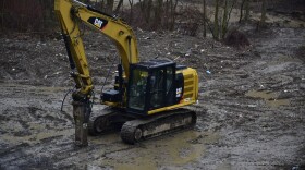 A piece of equipment sits in a soggy field of eastern Kentucky flood debris.