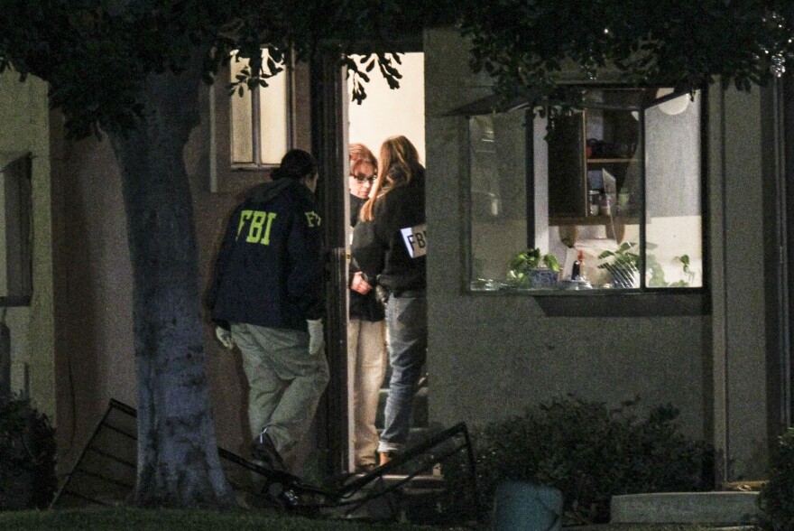 FBI agents search Thursday outside a home in Redlands, Calif., in connection with the San Bernardino shootings.