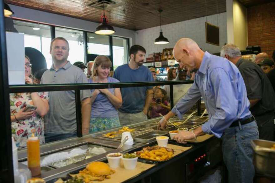 Governor Rick Scott gives 4Rivers a hand serving patrons. The restaurant, usually closed on Sundays, opened it's doors to raise money for Pulse charities. Photo: Governor's Office