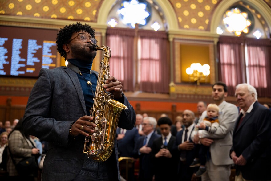 Saxophonist Derrick M. Roberts II opens proceedings with the national anthem.