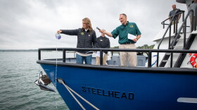 Michigan Department of Natural Resources Deputy Director Shannon Lot pours water over the bow of the RV Steelhead to christen it at the Sept. 30 ceremony.