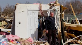 Steve McDonald stands in the debris from the home of his mother-in-law, Mary Osman, who died when a tornado touched down Wednesday in Harrisburg, Ill. She was one of five people killed on Brady Street.