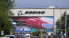 FILE - Traffic drives in view of a massive Boeing Co. production plant, where images of jets decorate the hangar doors, Friday, April 23, 2021, in Everett, Wash. Boeing says global geopolitical concerns are a big reason why it is dropping more than 100 planes from its backlog of pending orders. The company said Tuesday, April 12, 2022, that it cut its backlog by 141 planes, and about two-thirds of those are for what it termed geopolitical considerations including sanctions. (AP Photo/Elaine Thompson, File)