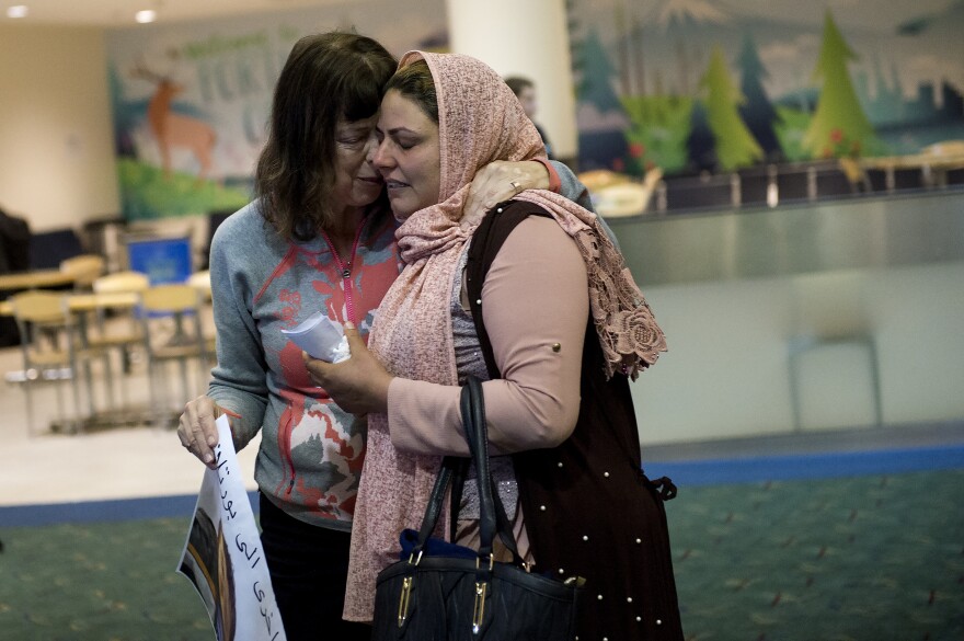 Geri Berg (left), a pediatric social worker who helped bring Mustafa to the U.S., hugs Mustafa's mother, Nidhal Aswad at the airport. Nidhal is concerned about the short supply of clean water needed to keep his colostomy free of infection near Mustafa's home in rural Iraq.