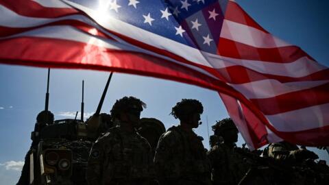 U.S. Army soldiers stand in formation next to a US flag and a U.S. Army armoured vehicle as they take part in the NATO "Noble Blueprint 23" joint military exercise at the Novo Selo military ground, northwestern Bulgaria, on September 26, 2023. (Nikolay Doychinov/AFP via Getty Images)