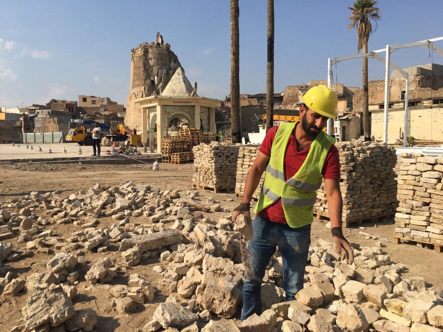 A worker in Mosul, Iraq, assesses the damage in the al-Nuri Mosque compound. Workers are reconstructing the mosque's al-Hadba minaret.