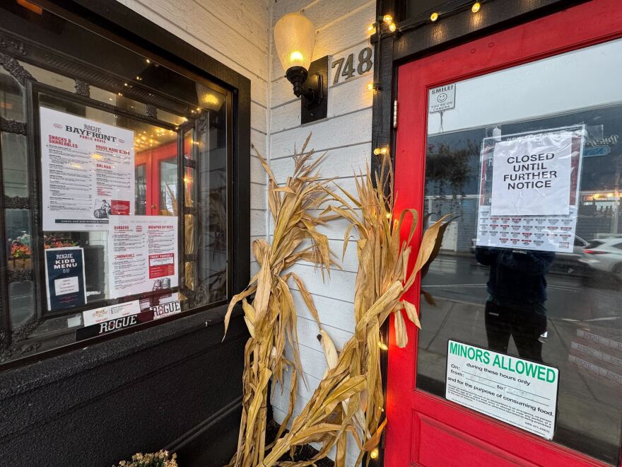 The exterior of a restaurant, decorated with an autumn theme. A sign on the door reads: "CLOSED UNTIL FURTHER NOTICE."