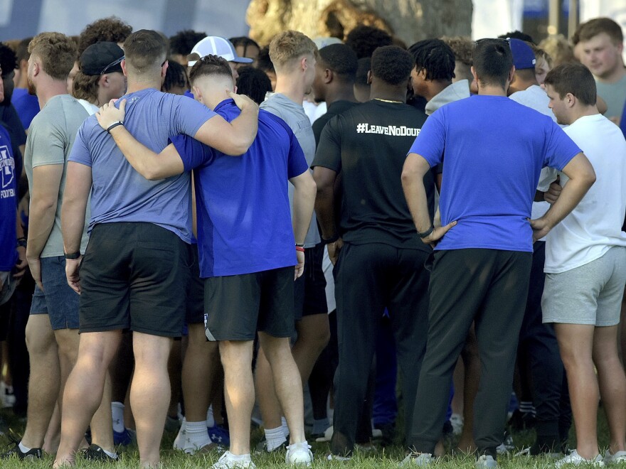 Members of the Indiana State football team console one another on Sunday, Aug. 21, 2022, for students, including fellow football players, who were involved in a car crash earlier in the day.