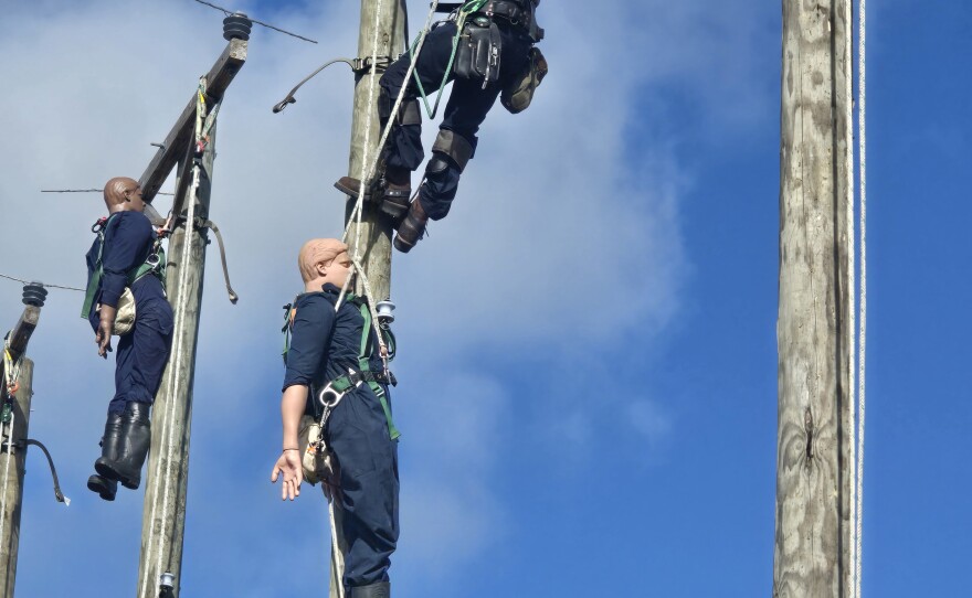 Florida linemen simulate rescuing an injured worker in competition at the 2026 Florida Lineman's Rodeo in Winter Garden.