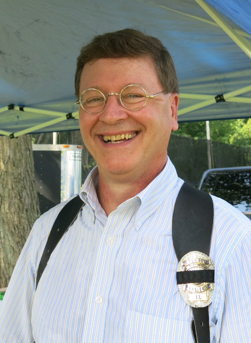 Smiling man with glasses with police badge