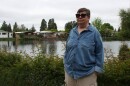 Deann Sweeper, a Marine veteran and Lakewood Vista Mobile Home Park residents, stands in front of the community's pond on May 6, 2026. Sweeper is the chair of the board of residents working to buy the park.