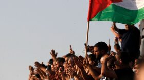 Mourners raise a Palestinian flag during the funeral of Mohammad Kiwan, a 17-year-old Palestinian who succumbed to his wounds after being shot during confrontations with Israeli troops last week, in the mostly Arab city of Umm al-Fahm in northern Israel.