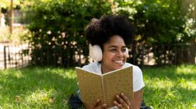 A woman listens to an audiobook with headphones. (Getty Images)