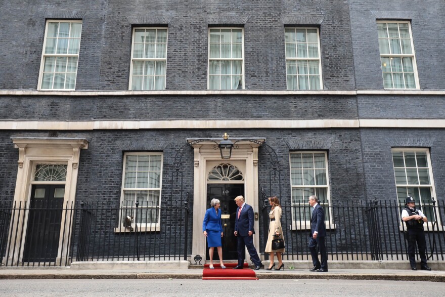 May, Trump, first lady Melania Trump and Philip May arrive at 10 Downing Street, the prime minister's residence, where a red carpet was rolled out to greet them. On a windowsill to the left, Chief Mouser Larry the Cat keeps watch.