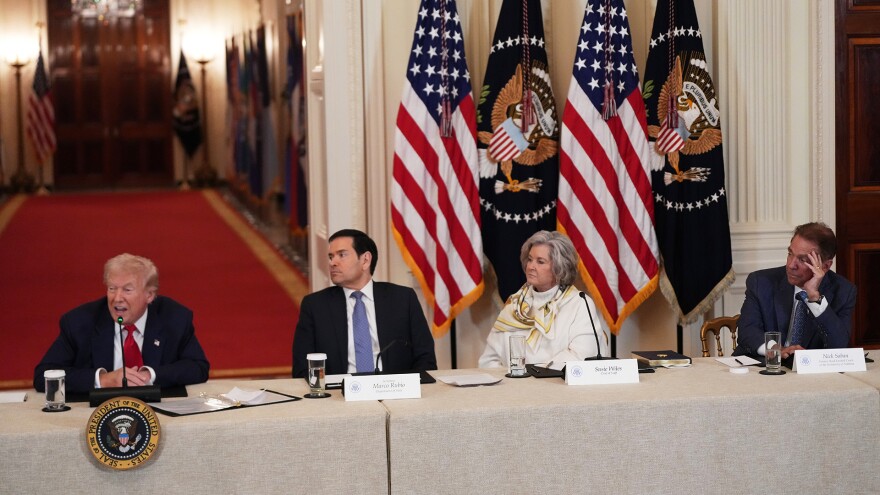 President Donald Trump, Secretary of State Marco Rubio, White House chief of staff Susie Wiles and former Alabama head coach Nick Saban attend a roundtable discussion on college sports in the East Room of the White House, Friday, March 6, 2026, in Washington. 