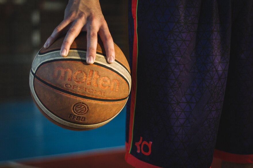 A man holding a basketball in one hand.