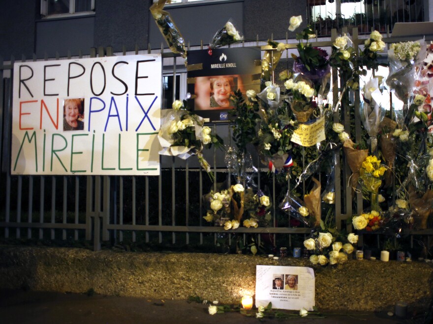 Flowers and placards are displayed outside Knoll's apartment in Paris in March. Knoll's death has taken on national importance.