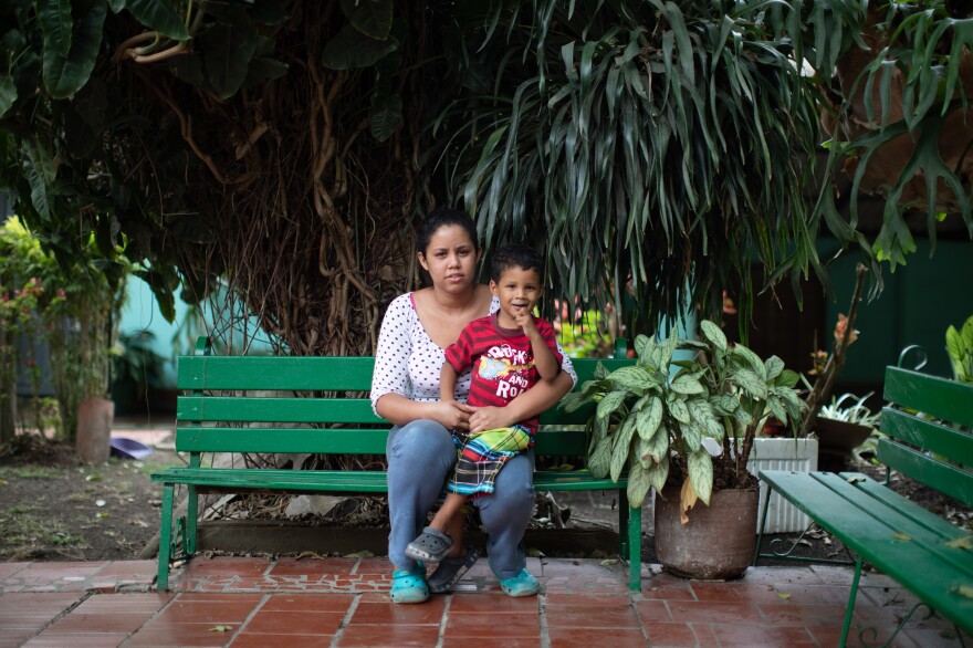 Jennifer Guanipa sits with her son. She prepares meals for migrants in a shelter in Curití, south of Bucaramanga, Colombia, in exchange for a place for her family to stay.
