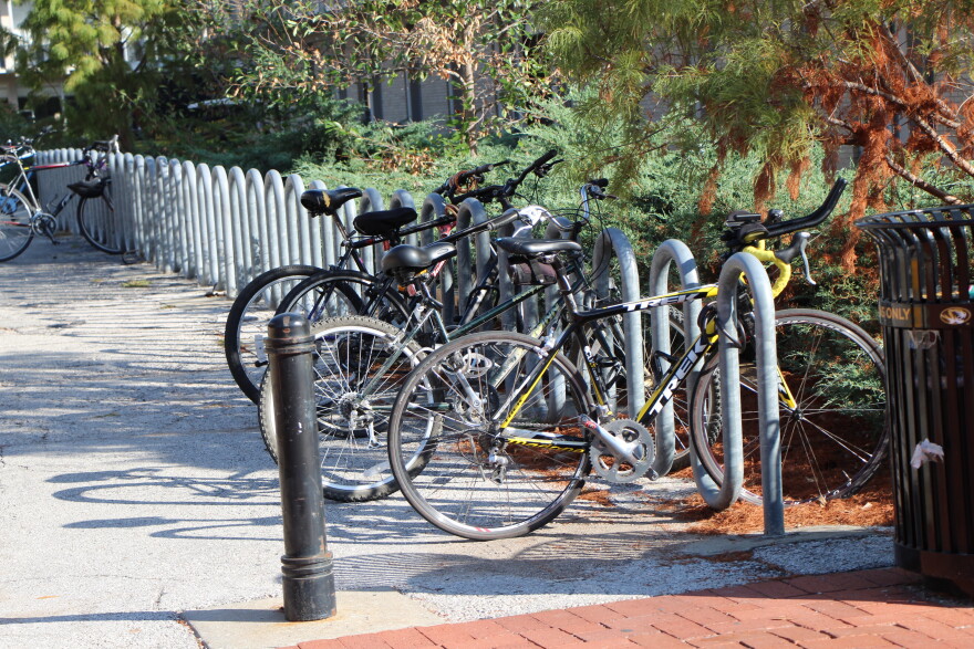 At least 4 bikes are locked at a bike rack. 