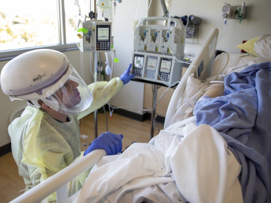In this photo provided by the Defense Visual Information Distribution Service, U.S. Army 1st Lt. Blaine Woodcock, a critical care nurse, provides care to a COVID-positive patient during the COVID-19 response operations at Kootenai Health regional medical center in Coeur d'Alene, Idaho, on Sept. 6, 2021.