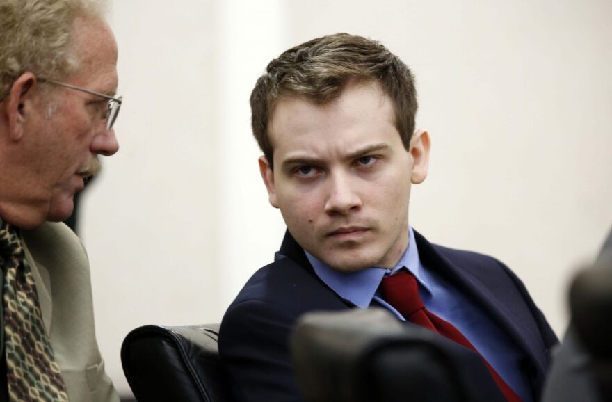 Pedro Bravo talks with a member of his defense team while they listen to testimony from Gainesville Police Crime Scene Investigator Mark Trahan in courtroom 1B of the Alachua County Criminal Justice Center Thursday, August 7, 2014. Bravo is accused of killing University of Florida student Christian Aguilar. (Doug Finger/The Gainesville Sun)