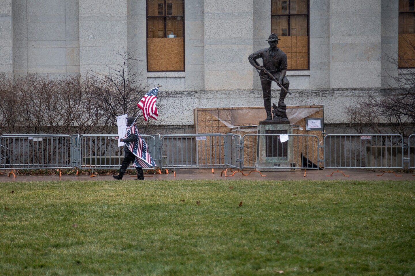 A right wing demonstrator walks past a WWI monument in front of the Ohio Statehouse during a planned Boogaloo Bois Demonstration, Ohio State Capitol, Columbus, Ohio. Sunday, Jan. 17, 2021