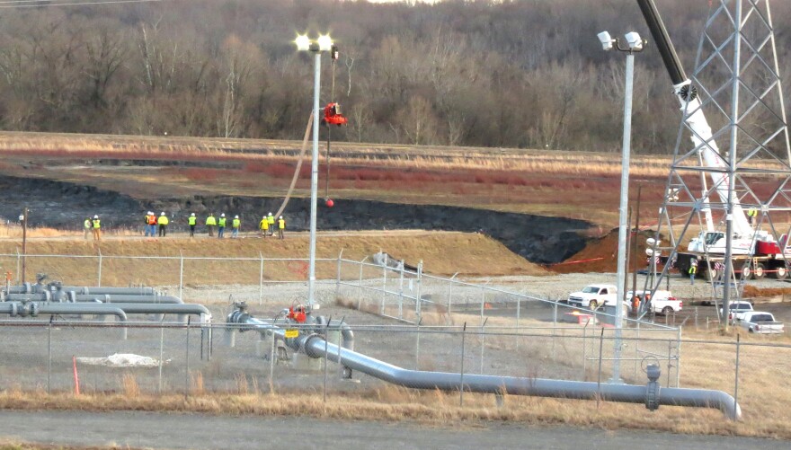 Duke Energy crews work to repair the broken coal ash pond. Coal ash is a byproduct of the coal burned to produce electricity.