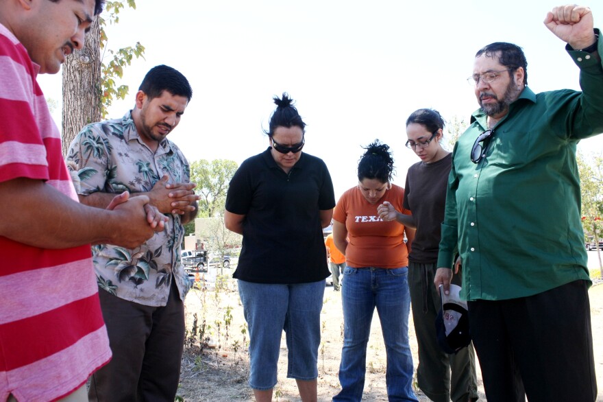 Austin Pastor Guillermo Alvarez leads a prayer on a sidewalk in Bastrop for family members whose Bastrop County home was in the crosshairs of the onrushing wildfire.