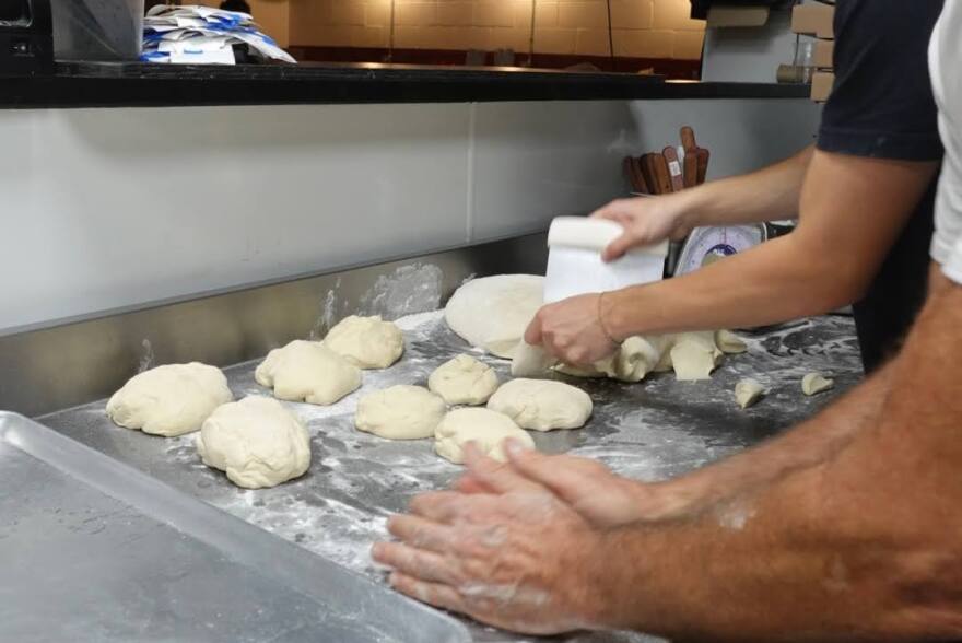 Dueño y miembro del personal midiendo y haciendo la pizza. Foto por: Valentina Echeverri.
