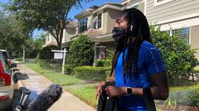 Protester Miles Mulrain speaks with reporters in front of the Windermere townhome of former Minneapolis police officer Derek Chauvin.