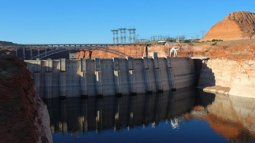 Lake Powell sits low behind Glen Canyon Dam on May 14, 2026. The new Colorado River plan aims to keep water levels high enough to pass through hydropower turbines inside the dam.