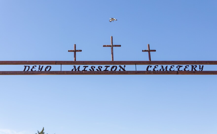 A bird flies off the Deyo Mission Church cemetery sign toward the resting place for many Comanches on May 21, 2025.