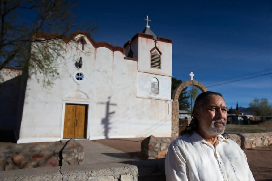 Isaac Melendrez Jr. sits in front of Our Lady of Purification Catholic Church in Doña Ana, N.M., on March 15, 2026. Melendrez lives only a mile from the church, where he was sexually abused by the priest as a child, but still avoids the immediate area.