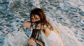 a woman in the ocean being splashed by waves 