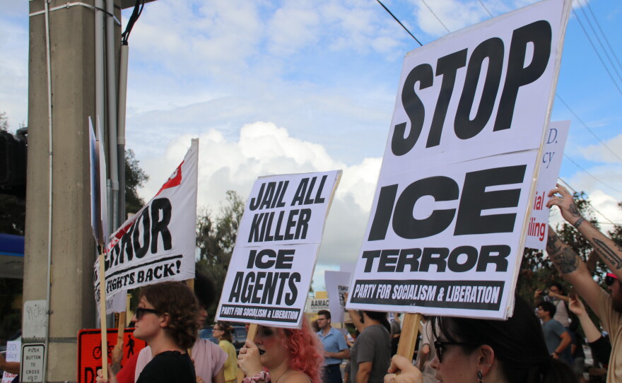 Gainesville residents wave “Stop ICE” signs at a protest against the new Gainesville Police Department general order. (María Sofía Rodríguez/WUFT News)