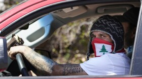 A man wears a face covering while driving in a motorcade rally to protest Gov. Janet Mills' support for offshore wind projects, Wednesday, April 28, 2021, in Augusta, Maine.