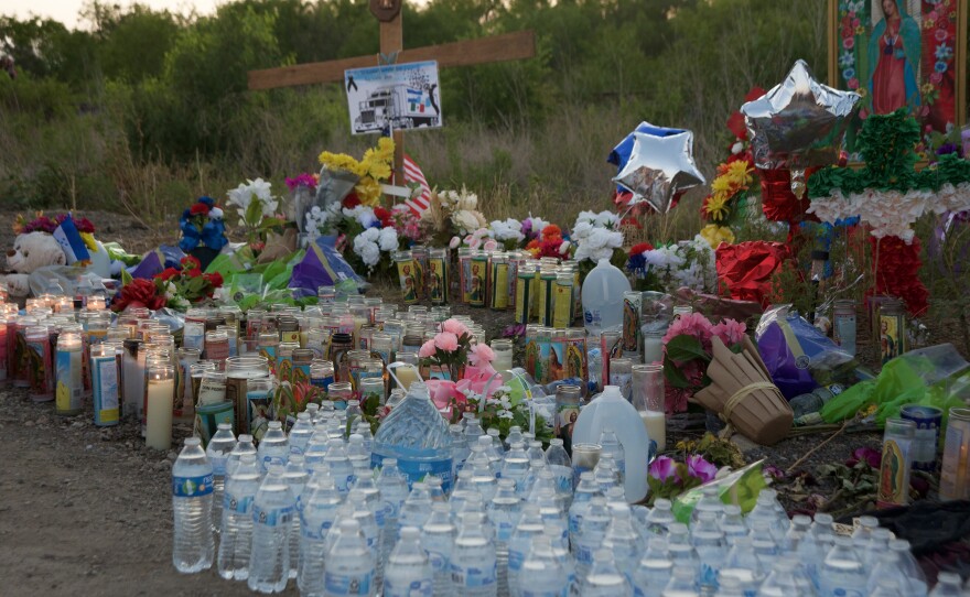 Se han colocado velas, botellas de agua y más en el sitio conmemorativo donde se encontraron decenas de personas atrapadas en un camión con remolque. Al menos 53 personas encontradas en el vehículo han muerto.