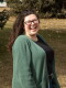 Emily Colby stands outside, laughing.